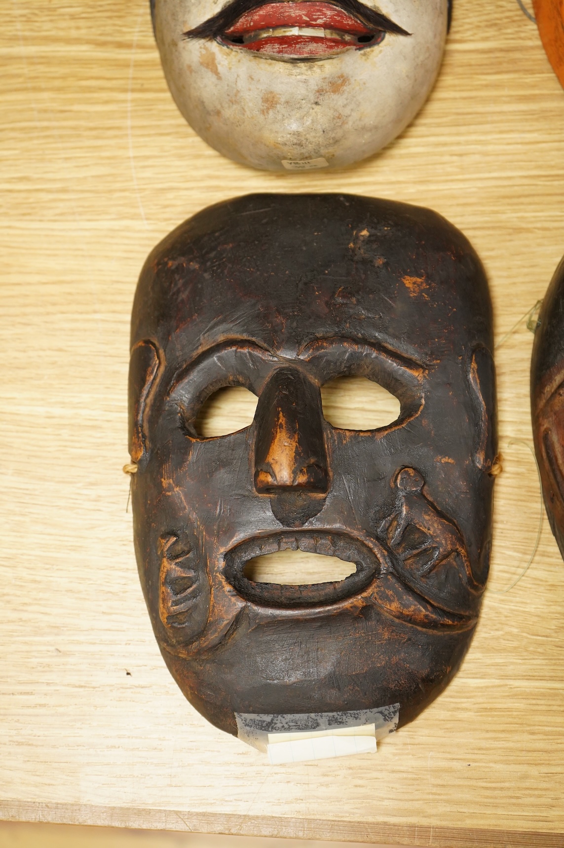 A collection of seven Nepalese, African and Indonesian masks to include a Magar example and one from the Dan Tribe, Liberia, largest 40cm
